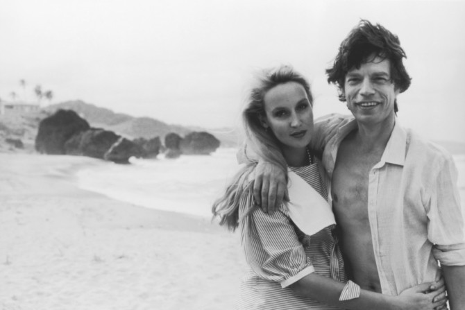 December 1983, Barbados --- Mick Jagger and girlfriend Jerry Hall on the beach at Barbados, just prior to his 40th birthday. --- Image by © Wally McNamee/CORBIS